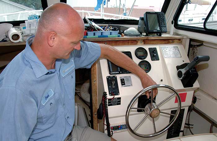 Man removing fill cap on steering.