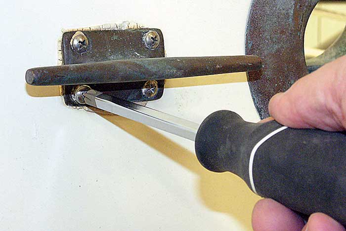 Man unscrewing a deck fitting.