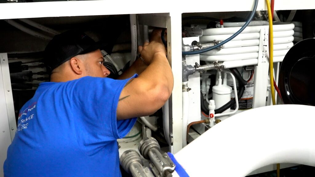 Man working on a generator on a boat.